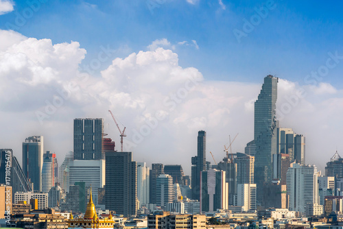 Wallpaper Mural Panoramic view of a modern city skyline with tall skyscrapers, construction cranes, and cloudy sky, symbolizing growth and urban development. Torontodigital.ca