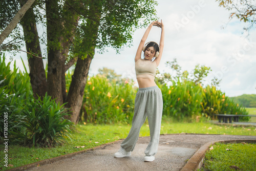Wallpaper Mural A sporty woman in sportswear exercises at the garden Torontodigital.ca