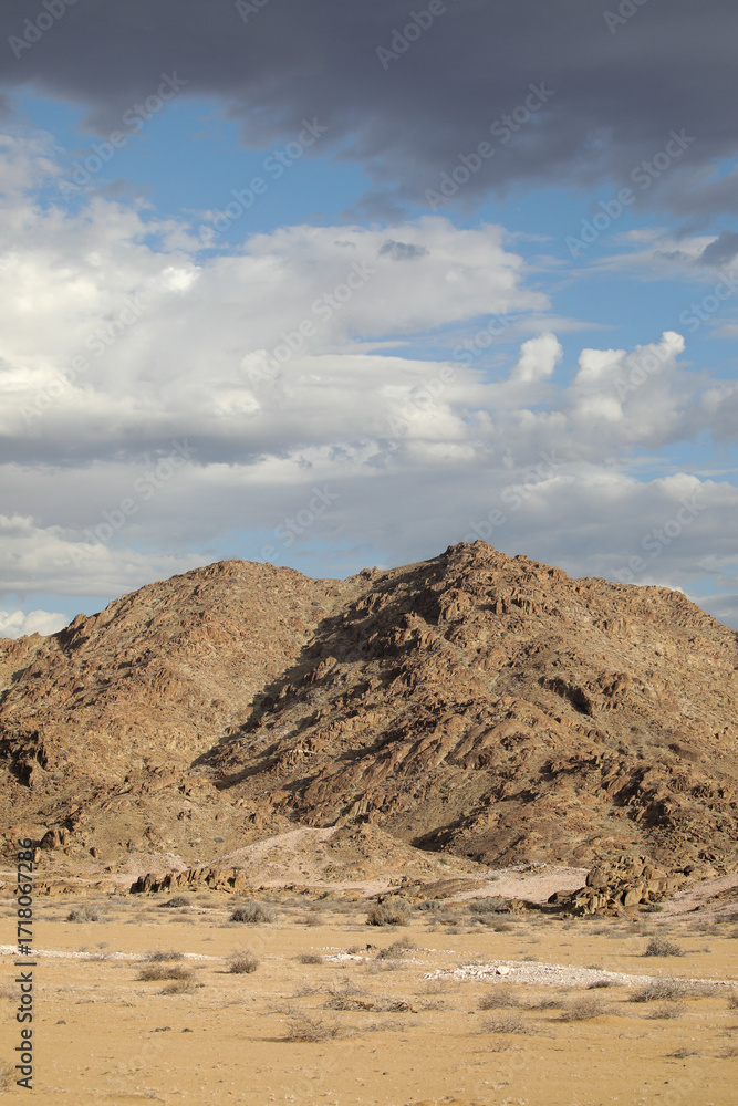 Fototapeta premium Rugged arid mountains of the Richtersveld desert area with summer storm clouds