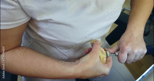 Prosthetics hands while working on the denture, false teeth, a study and a table with dental tools