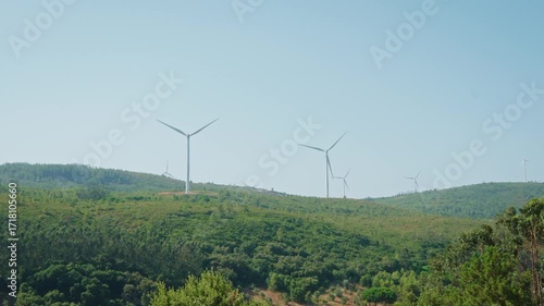 Wind Turbines Spanning Green Hills: Scenic Renewable Energy Landscape on a Distant Horizon