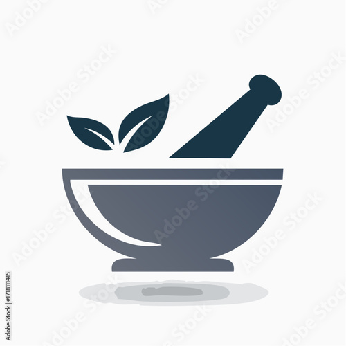 A dark gray mortar and pestle with two leaves on top.
