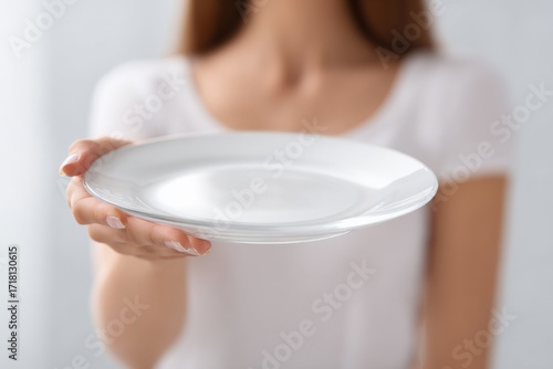 Woman presents blank ceramic plate