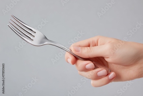 Fork held by a woman's hand closeup view