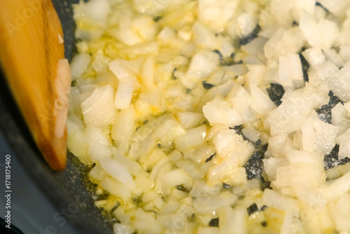 Wallpaper Mural Close-up wooden spatula cooking stirring chopped onions and garlic in frying pan on kitchen. Culinary techniques, homemade preparing healthy meal, cook food dish, cuisine, seasoning for meal taste. Torontodigital.ca