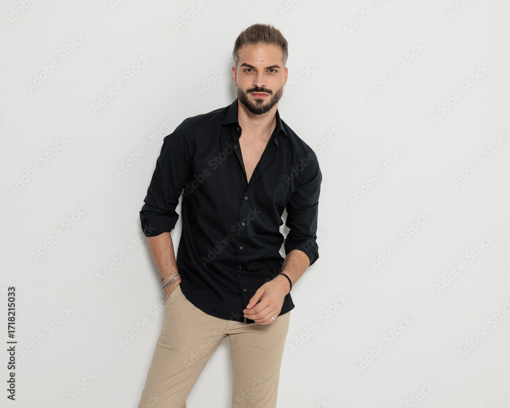 Fototapeta premium happy confident man holding hand in pockets, smiling and posing