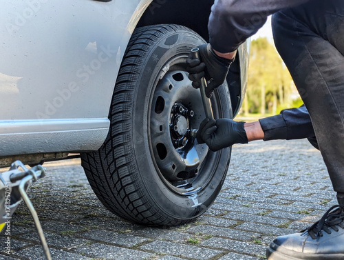 Seasonal tire change in progress, man working on car maintenance and repair. Concept of mobility, safety and vehicle care.
