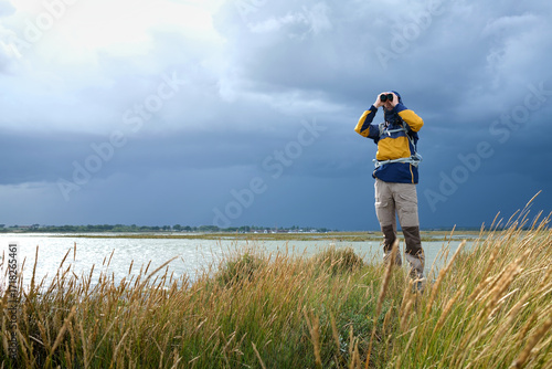 Man Observing Rising Sea Levels on a Coastal Marsh