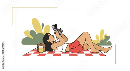 Young Woman Enjoying Photography While Relaxing On A Picnic Blanket Outdoors