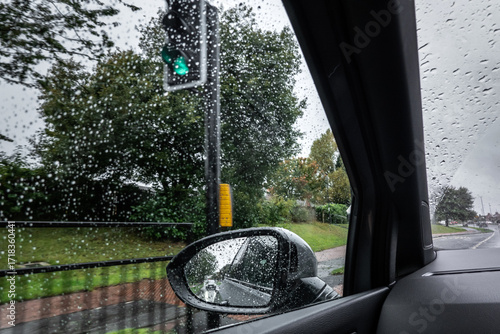 Side mirror view and go signal. Rainy day viewed through car. Go Light concept 