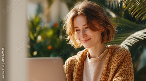 Young Woman Smiling While Working on Laptop in Bright Outdoor Garden Setting.