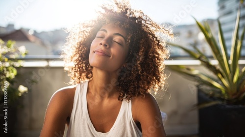 Woman Enjoying Bright Sunshine Outdoors with Relaxed Expression and Natural Curly Hair.