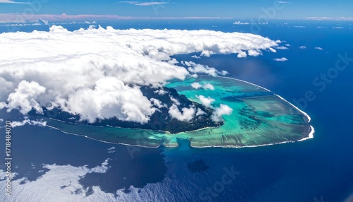 Aerial view of a tropical island surrounded by clouds and turquoise water