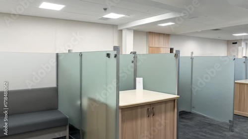 Wallpaper Mural Interior View of a Modern Office Space with Cubicles Featuring Gray Seating and Light Wood Cabinets Under Bright Ceiling Lights Providing Workplace Atmosphere Torontodigital.ca