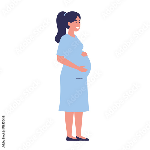 A pregnant woman in a blue dress stands sideways, gently holding her belly with a smile.