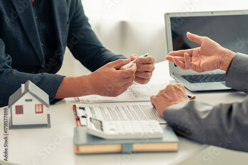 Real estate agent showing house plans to clients. Agent during meeting with interested clients, discussing details and offering investment opportunities. Close-up photo.