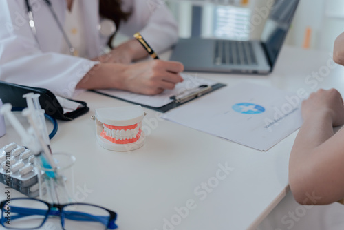 Dentists demonstrate dental models to patients in a clinic and explain dental treatments to patients using dental simulators and dental mirrors in the clinic.