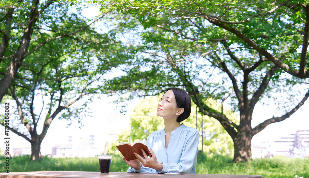 Fototapeta premium 屋外で読書する女性