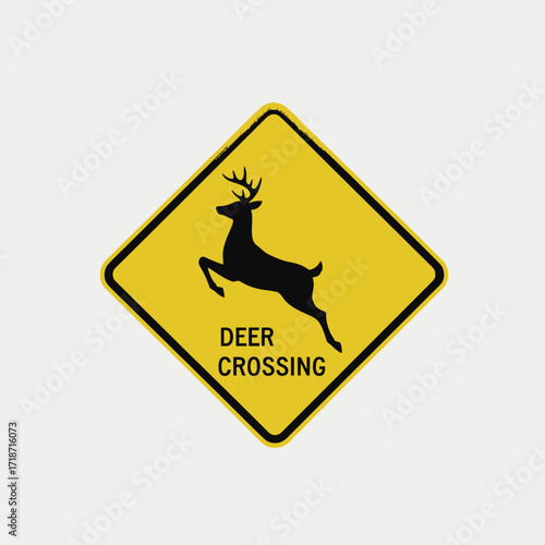 Yellow diamond-shaped road sign with a black deer silhouette and 'DEER CROSSING' text, indicating a wildlife warning for drivers.