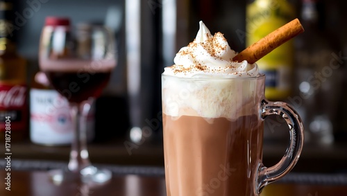 Spiked hot chocolate in a tall mug with whipped cream and cinnamon stick, cocktail bar background