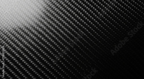 Close up of a black carbon fiber weave texture with light and shadow