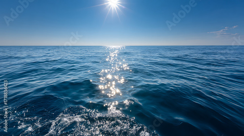 Fototapeta Naklejka Na Ścianę i Meble -  Ocean water under bright sun with sparkling reflections on calm blue sea surface on clear day