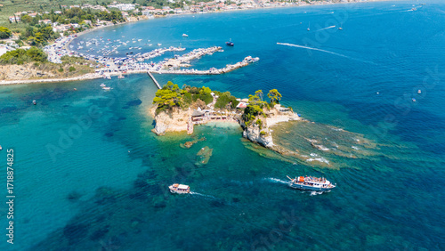 Aerial panorama of Cameo Island Zakynthos Greece surrounded by emerald and deep blue sea with boats cruising near iconic rocky islet