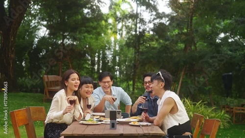 Wallpaper Mural Group of Happy Asian people diverse friends using mobile phone video recording together while celebration social gathering meeting dinner party eating food, drinking wine in the garden in evening. Torontodigital.ca