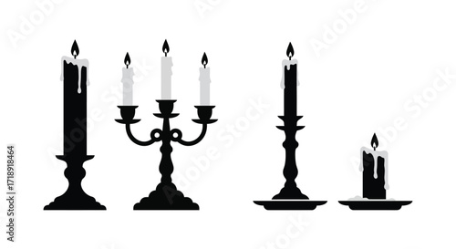 A collection of black and white candles and holders in silhouette