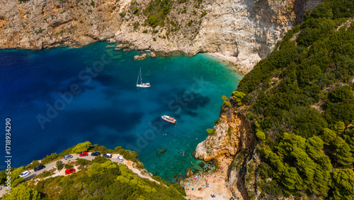 Filippoi beach secluded cove aerial with rocky cliffs crystal clear water anchored boats and green hills making a hidden summer paradise