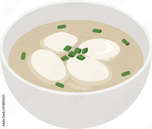 A bowl of Korean rice cake soup, featuring soft, white rice cakes in a light beige broth, garnished with green onions.