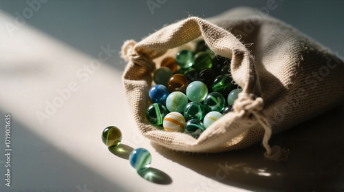 Colorful marbles spilling out of a fabric pouch with soft lighting  