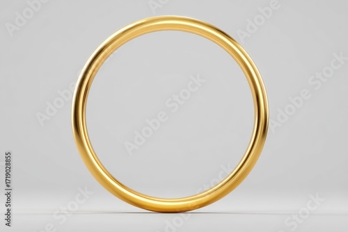 A thick, golden ring rests on a light grey surface