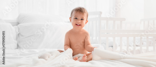 Little baby with towel sitt...