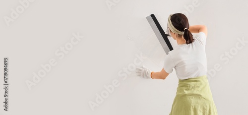 Young woman with putty knif...