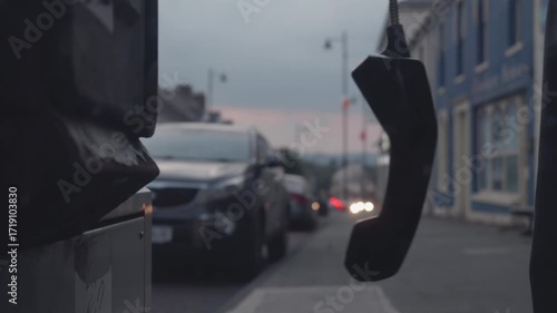 Exploring the charm of a quiet street as time slows down with a hanging phone in soft twilight