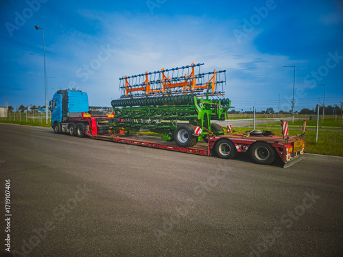 Heavy duty truck with agricultural machinery on low loader trailer