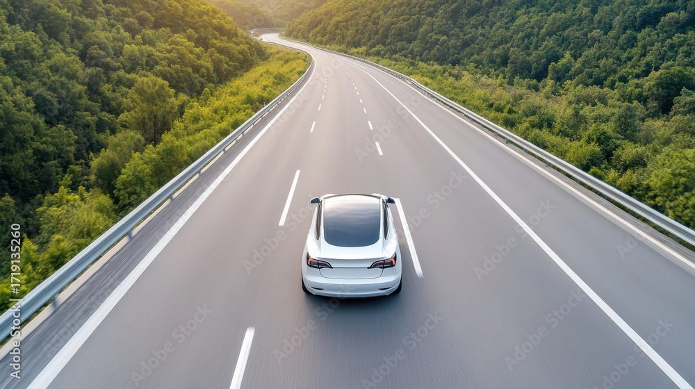 Obraz premium Sleek electric car drives smart highway surrounded by lush greenery, showcasing modern