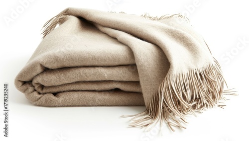 A beige, folded throw blanket with fringe rests on a white background.  The soft, textured fabric is neatly arranged in layers, showcasing its plush material