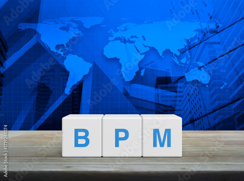 Fototapeta Naklejka Na Ścianę i Meble -  BPM acronym on white block cubes on wooden table over world map, office city tower and skyscraper, Business process management concept, Elements of this image furnished by NASA
