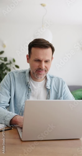 Adult man at home opening laptop typing