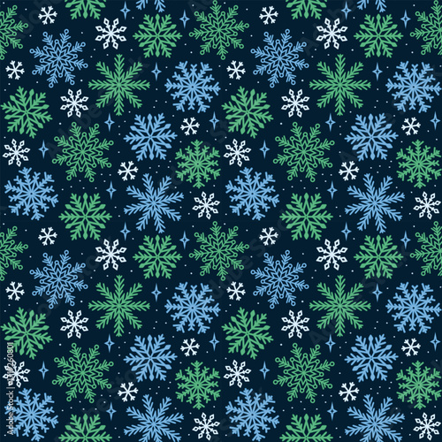 Seamless Snowflake Pattern Repeats on Dark Blue Background with Blue and Green Flakes