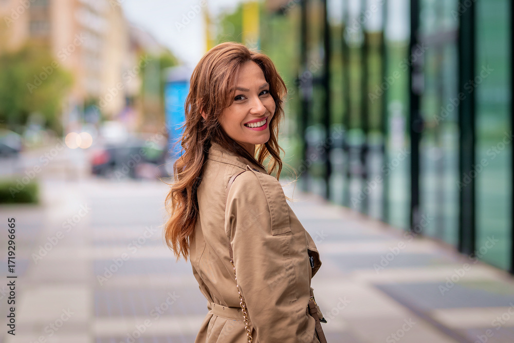Fototapeta premium A stylish middle-aged woman walking on an autumn day on a city street