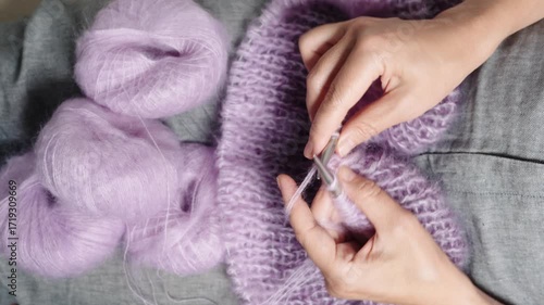 Top view of a woman knitting a sweater, traditional skills and handicrafts, real-time video, handheld shots with slight camera shake