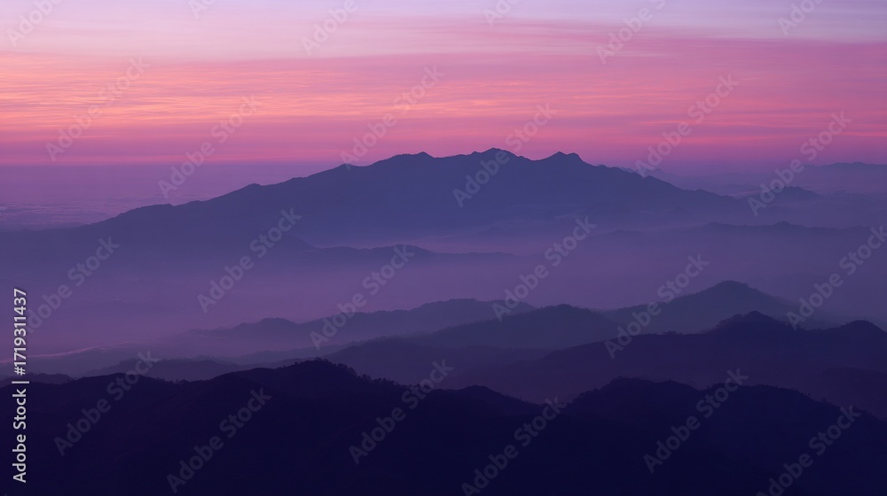 Fototapeta premium Majestic mountains stand tall under the twilight sky, where soft pink and purple hues blend gently with misty peaks, crafting an ethereal landscape that radiates calm and otherworldly beauty.