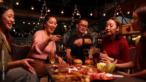 Happy Friends Celebrating Together at Night, Asian Group of Friends Having Fun and Toasting Drinks Outdoors, Enjoying a Celebration Concept.