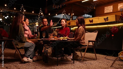 Happy Friends Celebrating Together at Night, Asian Group of Friends Having Fun and Toasting Drinks Outdoors, Enjoying a Celebration Concept.