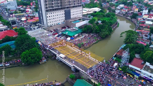 Drone footage of High-rise tower and busy streets during a cultural festival in the Philippines.