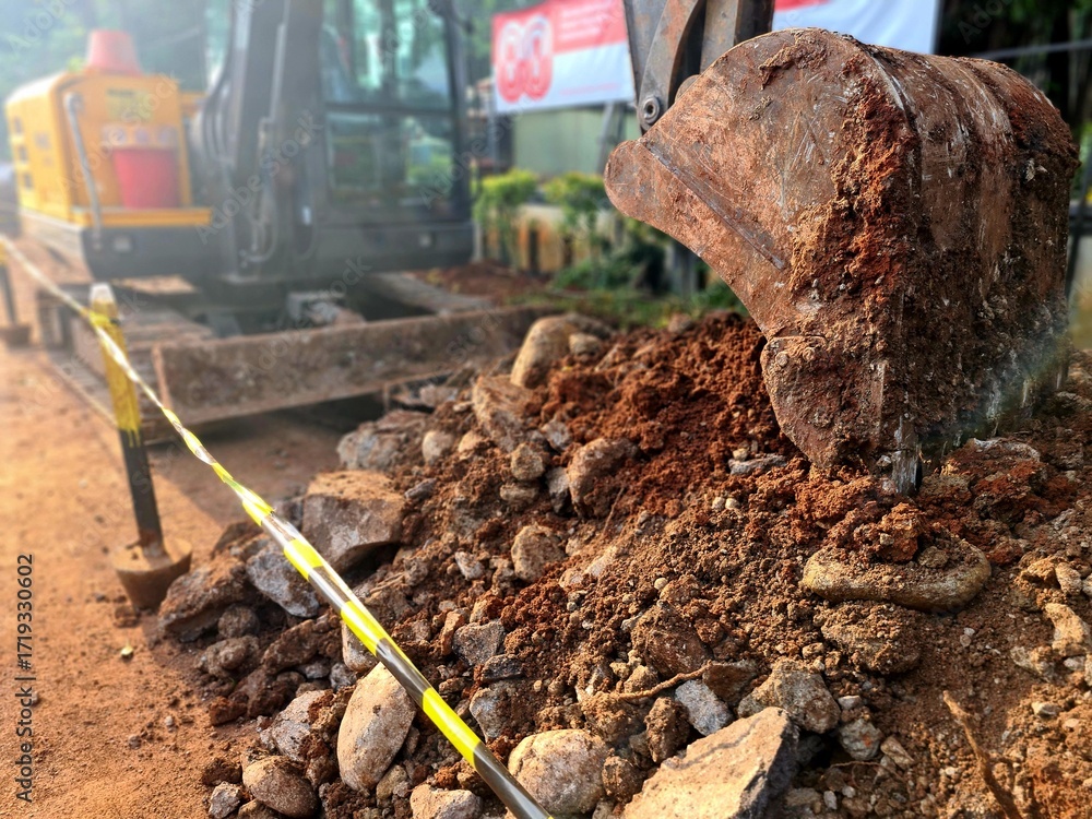 Fototapeta premium Excavator digging soil for drainage ditch construction