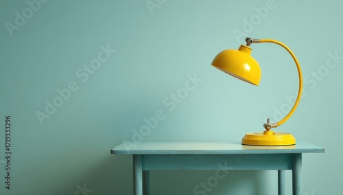 Yellow desk lamp on teal-colored table
